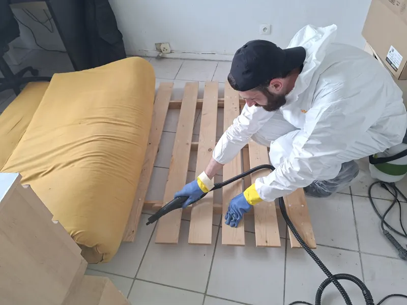 Technicien traitant un sommier à la vapeur sèche